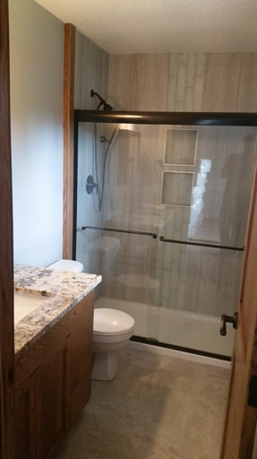 Bathroom with glass shower doors and tile inset shampoo niche