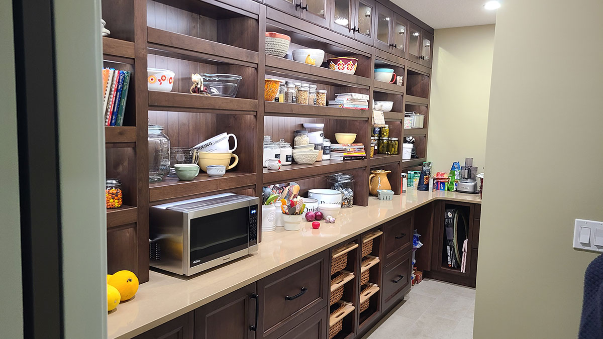Butlers pantry with countertops and numerous open shelves and closed cabinets