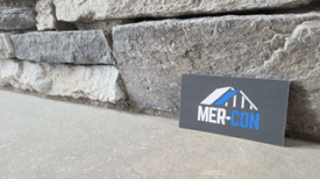 Mer-Con sign in front of rock siding