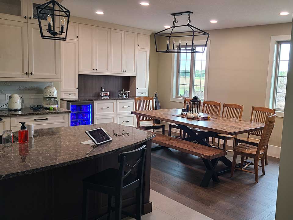 Kitchen with a dark wood island, large oak table and cream cabinets