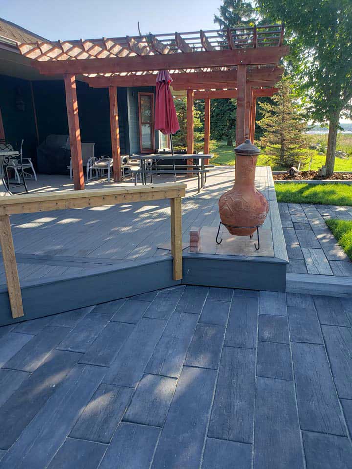 Gray composite deck with a low-rise platform and a pergola