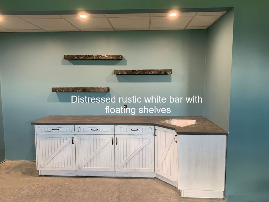 white rustic cabinets and floating shelves for basement wet bar