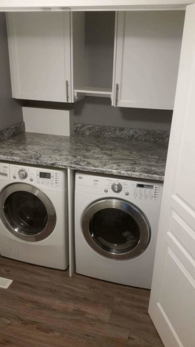 countertop above washer and dryer with upper cabinets