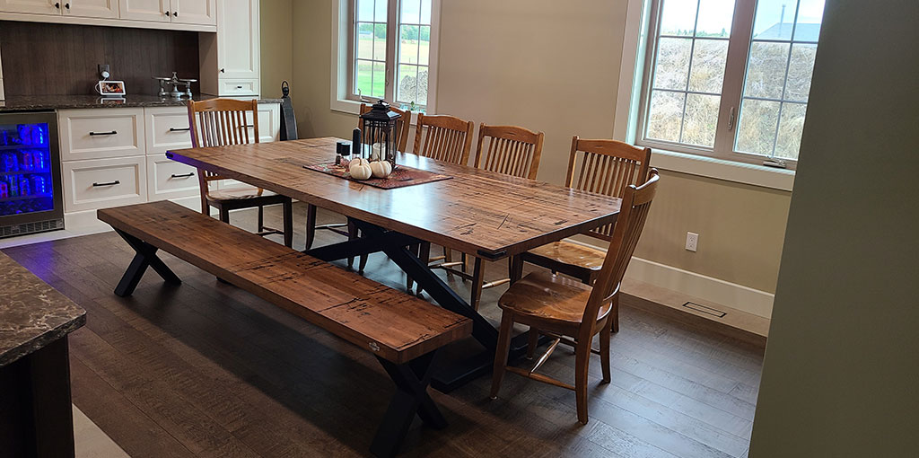 rustic table, bench and chairs in new renovated kitchen with dark hardwood floors and white cabinets