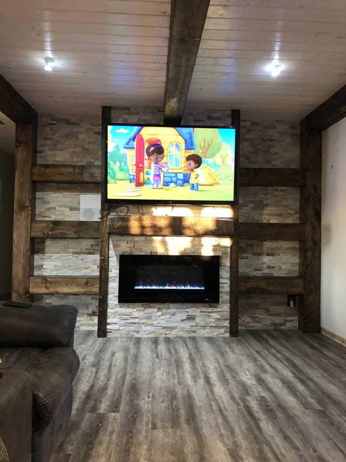 Basement family room with gas fireplace and tv over fireplace